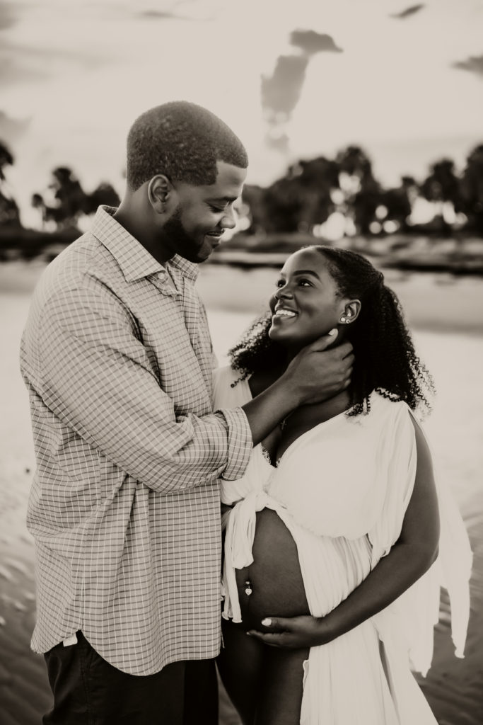 black and white couples pregnancy shoot in the water, clearwater beach fl