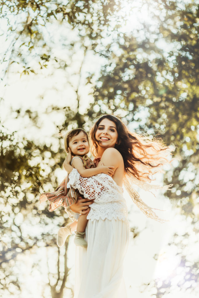 mother and daughter playing outdoors during a boho breastfeeding photo session in lakeland fl 