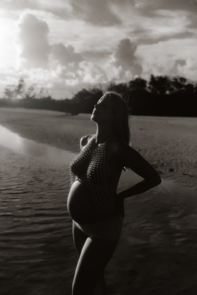 moody black and white pregnancy photo shoot taken in full direct sun at the beach in st Pete fl 